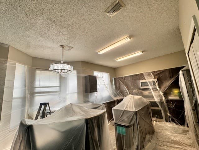 Interior room carefully masked and protected before painting walls, trim, and cabinets