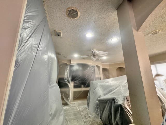 Interior repaint prep with furniture wrapped, floors covered, and surfaces ready for a clean finish