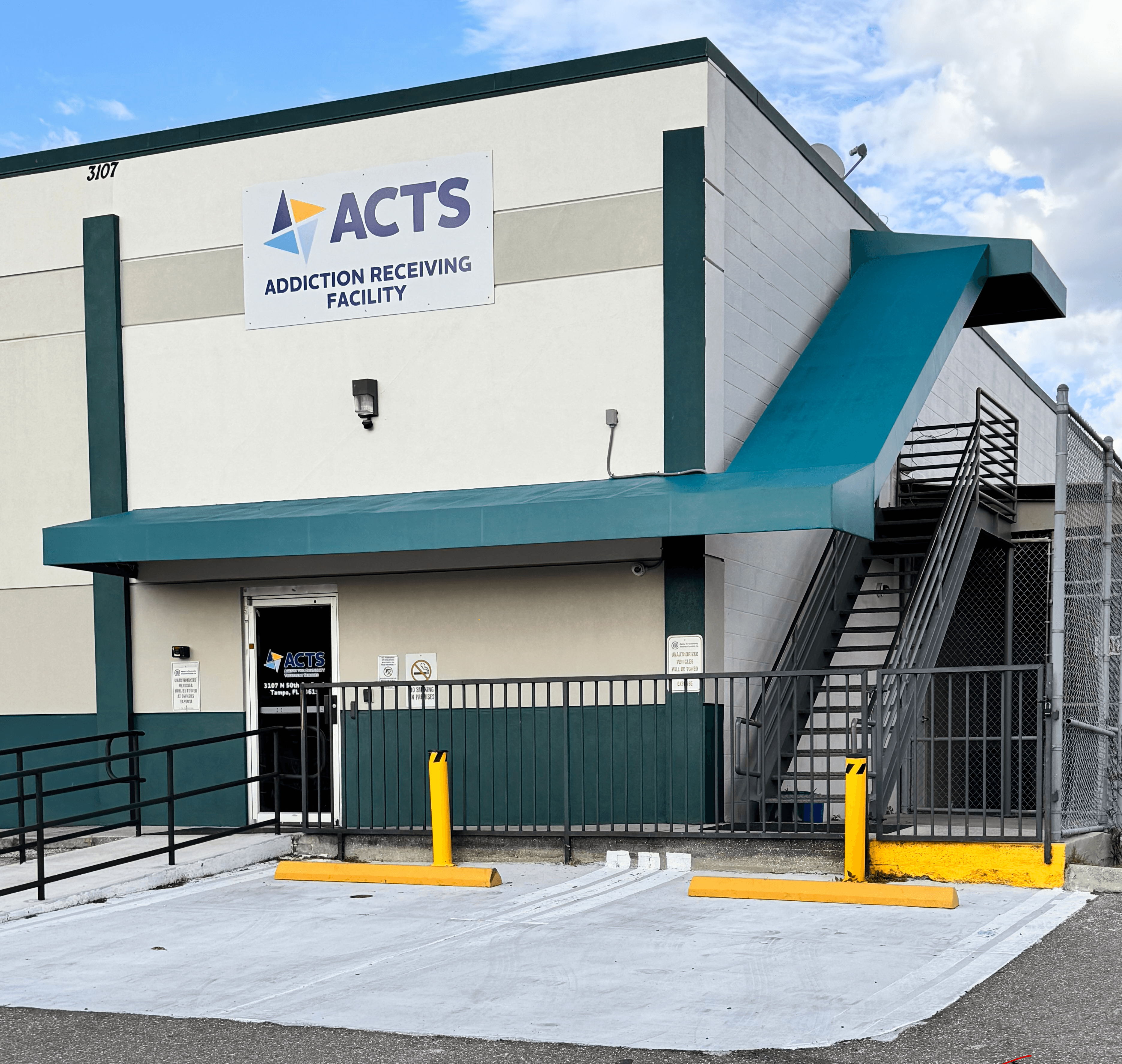 Finished commercial property exterior repaint with fresh white siding, blue trim, and a professional storefront
